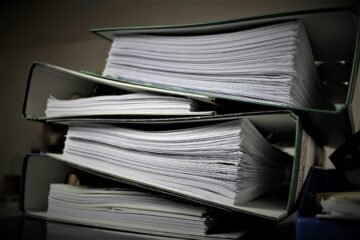 foto van een stapels ordners vol papierwerk als afbeelding bij een blog over bereken ieder jaar je jaarruimte